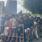 Menores migrantes no acompañados esperan a las puertas de la Jefatura Superior de Policía de Ceuta para que les registren.