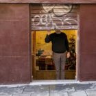 Un autónomo levantando la persiana de su negocio