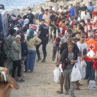 Miembros de la Cruz Roja atienden a varios inmigrantes, en la playa del Trampolín, a 20 de agosto de 2026, en Ceuta