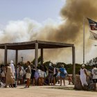 Varias personas desalojan la playa durante un incendio forestal, a 27 de agosto de 2026, en la Gola de Pujol, El Saler, Valencia, Comunidad Valenciana (España)