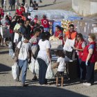 Miembros de la Cruz Roja reparten comida a los inmigrantes en una playa de Ceuta