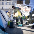 Un hombre recoge la basura en la acampada de Sol