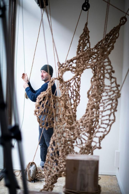 Raúl del Chano trabajando en una instalación artesanal realizada con fibra vegetal, tejida a mano en su taller.