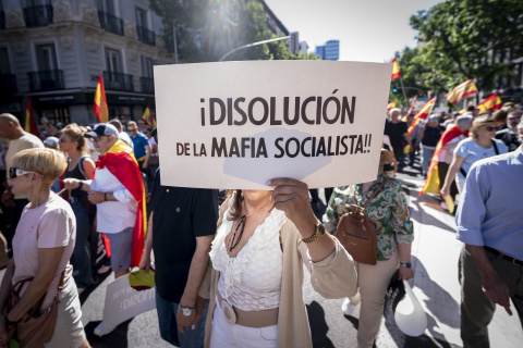 Una manifestante con una pancarta contra el PSOE